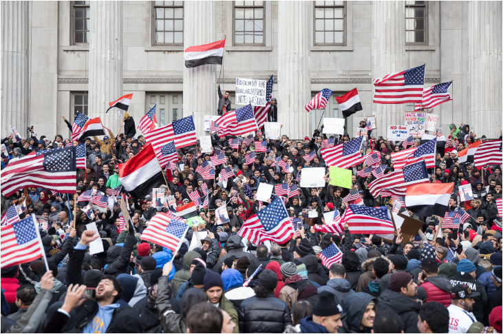 متظاهرون يرفعون أعلام اليمن والولايات المتحدة احتجاجاً على إنهاء وضع الحماية المؤقتة لليمن