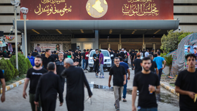 مدخل مجلس النواب العراقي في بغداد مع تجمع أشخاص أمام المبنى