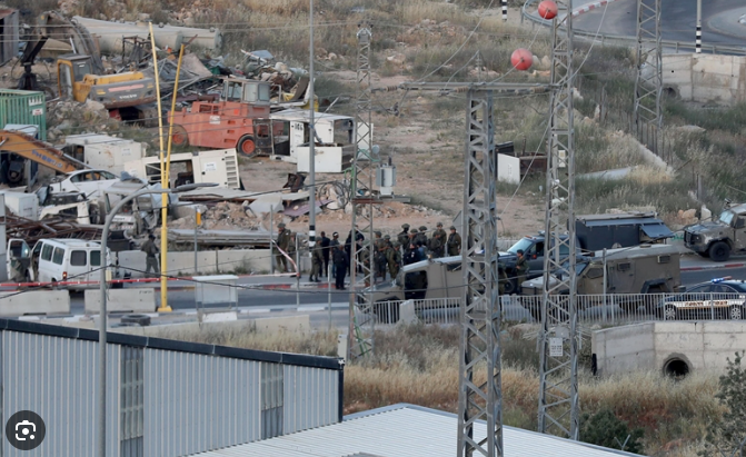 قوات أمن إسرائيلية تنتشر في موقع حادث أمني قرب منطقة صناعية في الضفة الغربية مع وجود مركبات عسكرية وأعمال إزالة في الخلفية