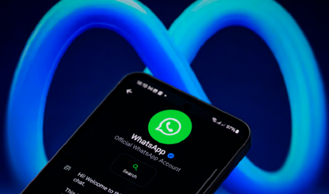 شعار واتس آب على هاتف ذكي أمام شعار ميتا في الخلفية