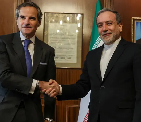 وزير الخارجية الإيراني عباس عراقجي يصافح مدير الوكالة الدولية للطاقة الذرية رافائيل جروسي خلال اجتماع رسمي في طهران