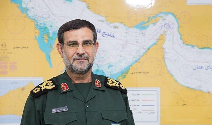 علي رضا تنكسيري قائد القوات البحرية في الحرس الثوري الإيراني أمام خريطة الخليج