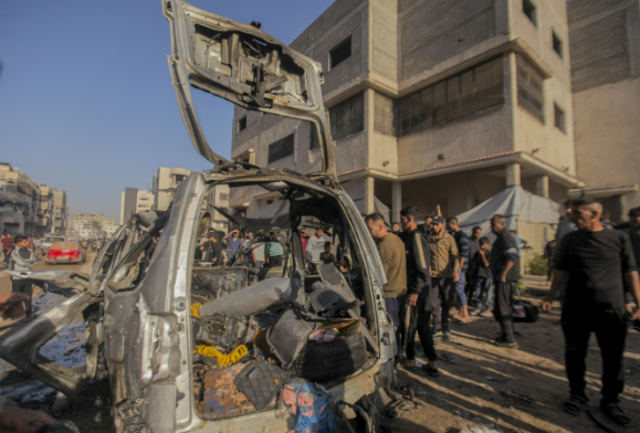 فلسطينيون يتفقدون موقع غارة إسرائيلية في غزة