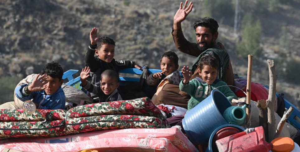 عودة المهاجرين الأفغان من باكستان عبر حدود باكستان أفغانستان مع عائلات تحمل أمتعتها